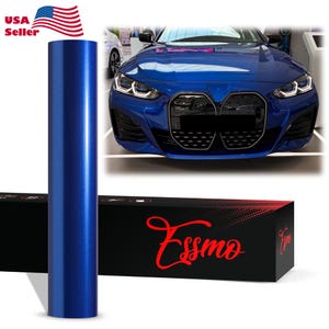 May include: A cylindrical roll of metallic blue vinyl wrap standing vertically next to a black rectangular box with the red text Essmo printed on the front. Behind the items is a blue car with a prominent front grille and LED headlights.