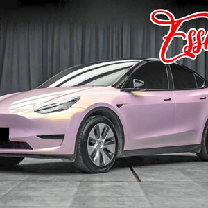 May include: A pink Tesla Model Y with black accents and tinted windows. The car is parked in a studio setting with a black backdrop.