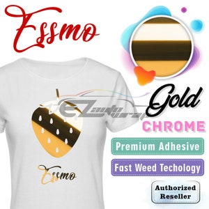 May include: A white t-shirt with a gold chrome strawberry graphic and the word "Essmo" written in black. The shirt is available in a gold chrome finish with a premium adhesive and fast weed technology. The text "Gold Chrome" is written in black and the text "Premium Adhesive" and "Fast Weed Technology" are written in white. The text "Authorized Reseller" is written in white on a purple background.