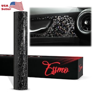 May include: Black and silver vinyl wrap with a swirling pattern. The wrap is shown on a roll and applied to a car interior panel. The packaging is black with red text that says "Essmo".