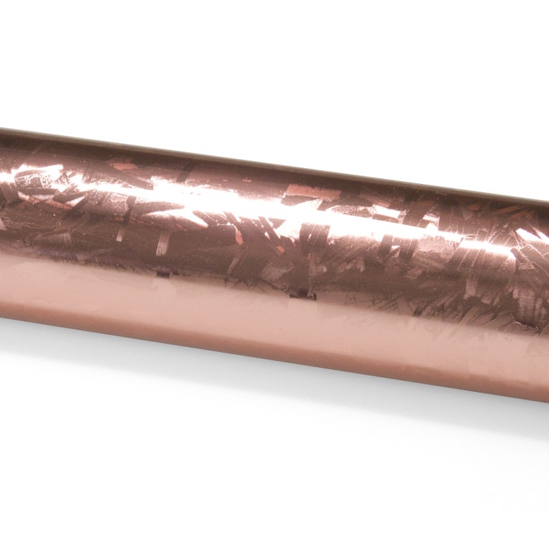 May include: A roll of rose gold wrapping paper with a metallic finish and a subtle pattern.