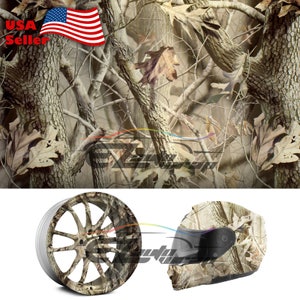 May include: A camouflage pattern featuring a close-up of tree branches and leaves in shades of brown, beige, and white. The pattern is ideal for use on a variety of surfaces, including vehicles, helmets, and other objects.