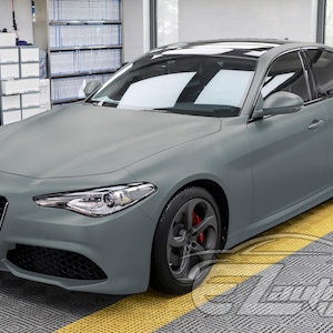 May include: A matte gray Alfa Romeo Giulia sedan featuring a distinctive triangular front grille, sleek headlights, and dark gray alloy wheels with visible red brake calipers. The vehicle has a smooth, non-reflective finish and a black roof panel.