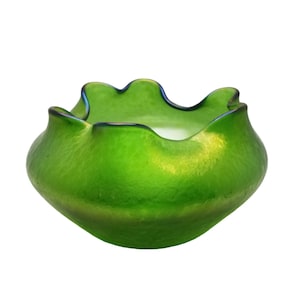 May include: A green glass bowl with a ruffled edge. The bowl has a textured surface and a dark blue rim. The bowl is a vibrant green colour and has an organic shape.