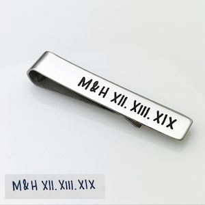 May include: Silver tie clip with the inscription "M&H XII. XIII. XIX" engraved on it.