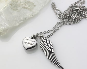 May include: A silver necklace with a heart-shaped pendant and a wing charm. The heart pendant has the inscription "My Sister my Angel".