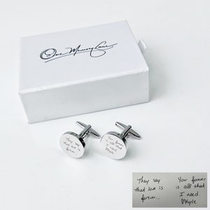 May include: A pair of silver cufflinks with engraved messages. The cufflinks are in a white box with the words "One Memory Lane" written on the top. The messages on the cufflinks are "They say that love is forever..." and "Your forever is all that I need. Phyle".