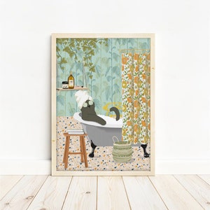 Op de afbeelding: Een grijze kat met een wit hoofdband en een oogmasker ontspant in een bad vol bubbels. De badkamer heeft een groen-blauwe bloemenbehang, een houten kruk en een rieten mand.