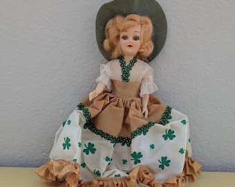 Muñeca vintage con tréboles verdes y vestido con ribetes dorados