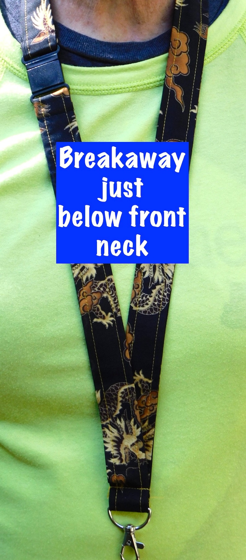 May include: A black and gold lanyard with a dragon pattern. The lanyard has a breakaway clasp just below the front neck.