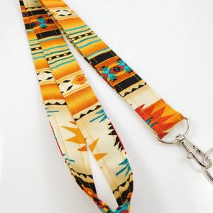 Sleutelkoord met zuidwestelijk design in goud, oranje en zwart, sleutelkoord voor leraren, sleutelhouder als cadeau voor collega's, sleutelkoord met Azteekse inspiratie.