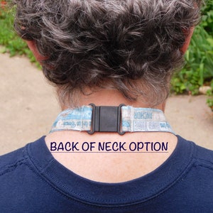 May include: A close-up of the back of a person's neck wearing a blue and white lanyard with a black plastic buckle. The lanyard has the text "Anchor Hocking" and "Roll Call Tribe" printed on it. The text "BACK OF NECK OPTION" is printed below the lanyard.