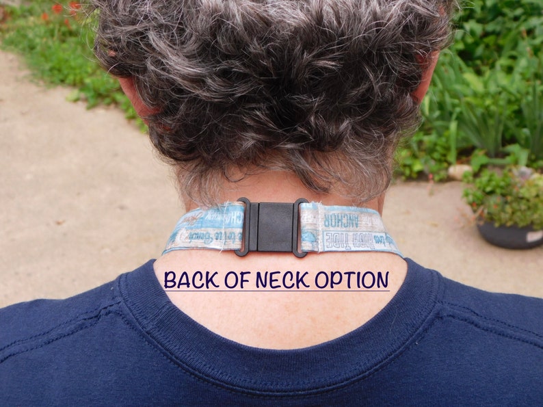 May include: A close-up of the back of a person's neck wearing a blue and white lanyard with a black plastic buckle. The lanyard has the text "Anchor Hocking" and "Roll Call Tribe" printed on it. The text "BACK OF NECK OPTION" is printed below the lanyard.
