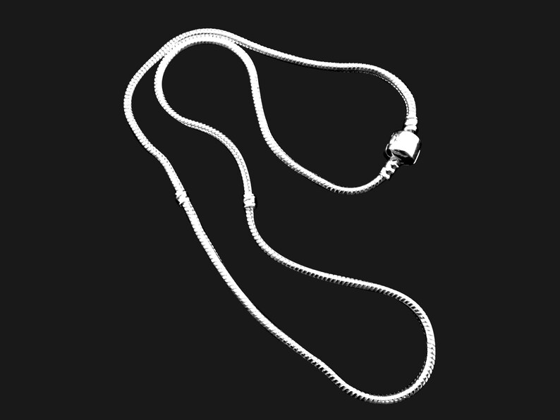 Puede incluir: Un collar de cadena de serpiente en tono plateado con una estructura de eslabones lisos y flexibles. La cadena incluye un dije de cuenta cil&iacute;ndrica de metal posicionado a lo largo del hilo y dos peque&ntilde;os topes met&aacute;licos fijos para asegurar el dije.