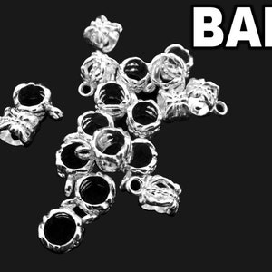 Puede incluir: Una colecci&oacute;n de asas para joyer&iacute;a de metal plateado, cada una con un dise&ntilde;o texturizado en forma de corona con una abertura circular central y un peque&ntilde;o lazo en la parte superior para su fijaci&oacute;n. La palabra BAIL aparece en blanco arriba.