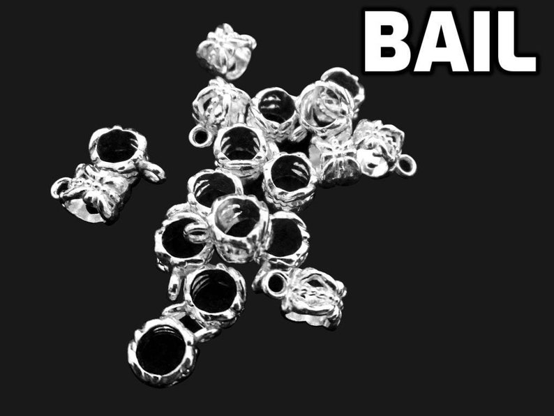 Puede incluir: Una colecci&oacute;n de asas para joyer&iacute;a de metal plateado, cada una con un dise&ntilde;o texturizado en forma de corona con una abertura circular central y un peque&ntilde;o lazo en la parte superior para su fijaci&oacute;n. La palabra BAIL aparece en blanco arriba.