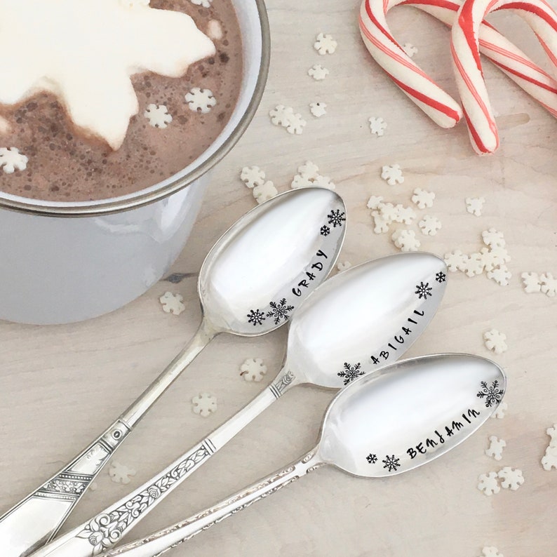 May include: Three silver spoons with snowflake designs and personalized names: Grady, Abigail, and Benjamin.