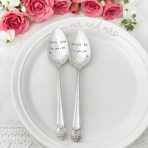 Puede incluir: Dos cucharas de plata con mensajes grabados, "love you 9.24.97" y "still do 9.24.22", en un plato blanco con las palabras "mr. and mrs." escritas en el plato.