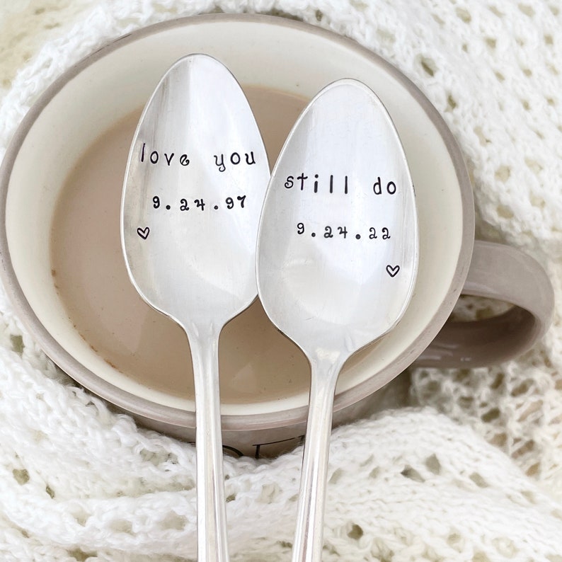 Puede incluir: Dos cucharas de plata con mensajes grabados. La primera cuchara dice "love you 9.24.97" con un peque&ntilde;o coraz&oacute;n. La segunda cuchara dice "still do 9.24.22" con un peque&ntilde;o coraz&oacute;n.
