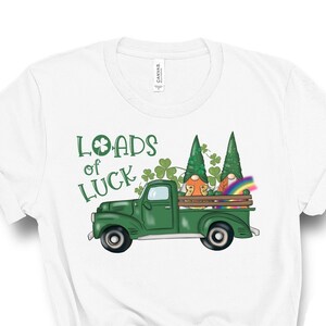 May include: White t-shirt with a green truck carrying two gnomes and a rainbow. The truck has the text "Loads of Luck" on the side.