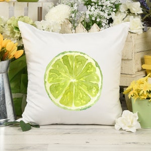 May include: White throw pillow with a watercolor illustration of a lime slice. The lime is green and yellow and has a white background.