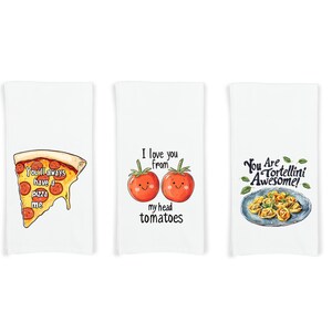 May include: Three white kitchen towels with different food-themed designs. The first towel features a slice of pizza with the text "You'll always have a pizza me". The second towel features two red tomatoes with faces and the text "I love you from my head tomatoes". The third towel features a plate of tortellini with the text "You Are Tortellini Awesome!"