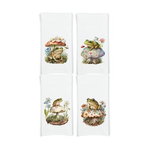 May include: Set of four kitchen towels featuring a green frog sitting on a mushroom with flowers. Each towel has a different design with a variety of colors.