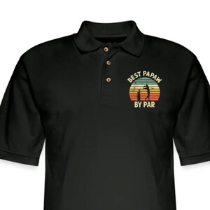 Puede incluir: Camiseta polo negra con un gr&aacute;fico de estilo vintage que dice "Best Papaw By Par" con una silueta de un golfista.