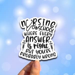 May include: A white sticker with black text that reads "Nursing School Where Every Answer is Right But You're Probably Wrong". The sticker features a stethoscope and two syringes.