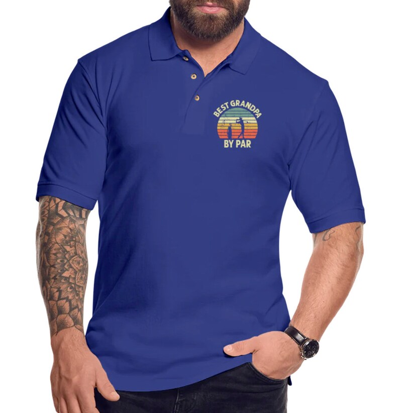 May include: A royal blue polo shirt with a vintage-style graphic of a golfer and the text "Best Grandpa By Par".