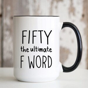 May include: White ceramic mug with black handle and rim. The mug features the text "FIFTY the ultimate F WORD" in black, bold font. A humorous gift for a milestone birthday.