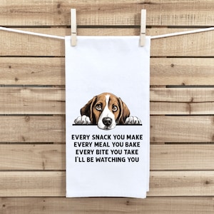 May include: A white kitchen towel with a brown and white beagle dog peeking over the top. The text on the towel reads "Every snack you make, every meal you bake, every bite you take, I'll be watching you."