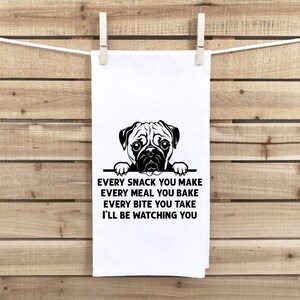 May include: A white kitchen towel with a black and white illustration of a pug peeking over the top. The text reads "Every snack you make, every meal you bake, every bite you take, I'll be watching you."