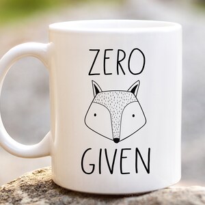 May include: White ceramic mug with a black and white illustration of a fox and the text "ZERO GIVEN".