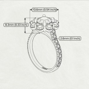 May include: A silver ring with a flower-shaped center featuring a large round gemstone surrounded by six smaller round gemstones. The band is adorned with a row of smaller round gemstones.