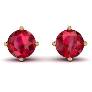 Puede incluir: Un par de pendientes de botón de oro con piedras redondas de rubí rojo.