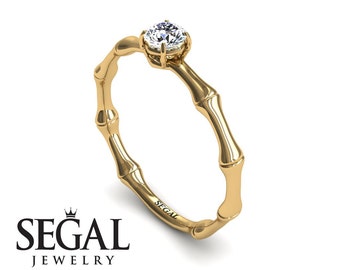 May include: A gold bamboo-style ring with a single round diamond set in the center. The ring is engraved with the word "SEGAL".