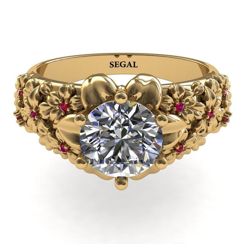 May include: A gold engagement ring with a large round diamond center stone. The band is decorated with a floral design and small red gemstones.