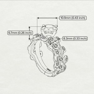 May include: A silver ring with a large, round, clear centre stone and a floral design with smaller stones. The ring is 10.9 mm wide, 6.7 mm tall, and 8.3 mm thick.