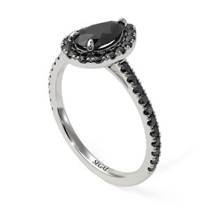 May include: A pear-shaped black diamond engagement ring with a halo of smaller black diamonds. The band is also set with black diamonds. The ring is made of white gold and is engraved with the word "SEGAL".