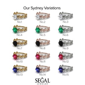 May include: A set of 15 engagement rings with different colored gemstones. The rings are all made of gold, rose gold, or silver and feature a delicate leaf design. The gemstones include emerald, ruby, sapphire, and black diamond.