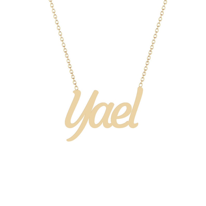 Puede incluir: Un collar dorado con el nombre "Yael" en cursiva. El colgante est&aacute; suspendido de una delicada cadena. El collar se muestra sobre un fondo blanco.