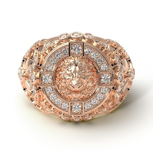 Könnte beinhalten: Ein goldener Ring mit einem Löwenkopf-Design, das von Diamanten umgeben ist. Der Ring hat ein detailliertes, verziertes Design.