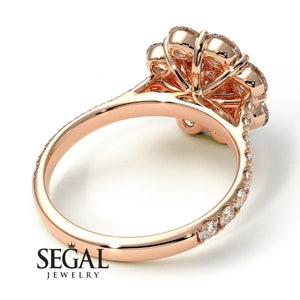 May include: Rose gold engagement ring with a large center diamond surrounded by smaller diamonds. The band is also set with diamonds.