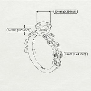 May include: A silver ring with a large, clear, round gemstone surrounded by smaller gemstones. The band is decorated with leaf-like designs. The ring measures 0.39 inches in diameter and 0.26 inches in height.