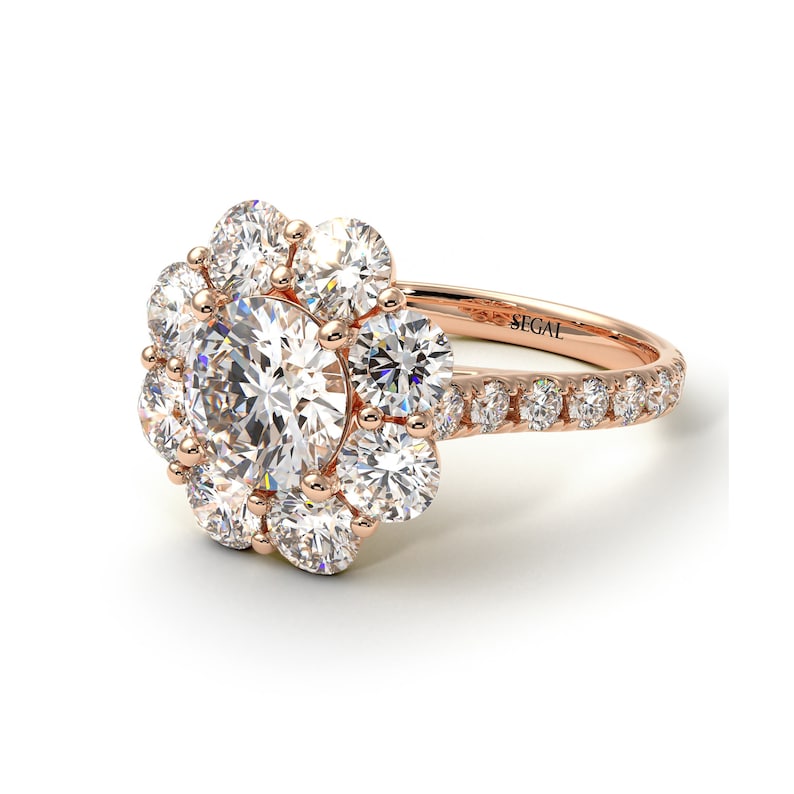 May include: A rose gold engagement ring with a large round center diamond surrounded by smaller diamonds in a flower shape. The band is also set with diamonds.