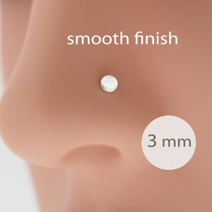 Peut inclure: Gros plan d'un clou de nez argenté avec une finition lisse. Le clou mesure 3 mm de diamètre.