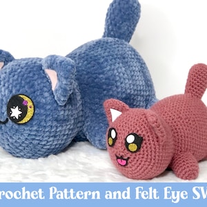 May include: Two crocheted cat plushies, one blue and one pink. The blue cat has a crescent moon and stars on its eye. The pink cat has a tongue sticking out. Crochet pattern and felt eye SVG.