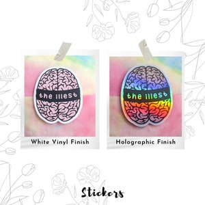 May include: Two brain-shaped stickers with the text "the illest" on them. The sticker on the left has a white vinyl finish and the sticker on the right has a holographic finish.