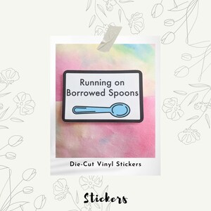 May include: Die-cut vinyl sticker with a blue spoon and the text "Running on Borrowed Spoons".
